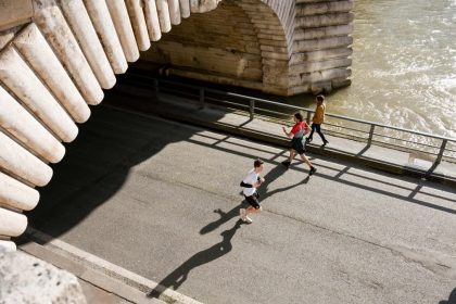 View of joggers running under the Pont de Bir-Hakeim in Paris, France during the day.