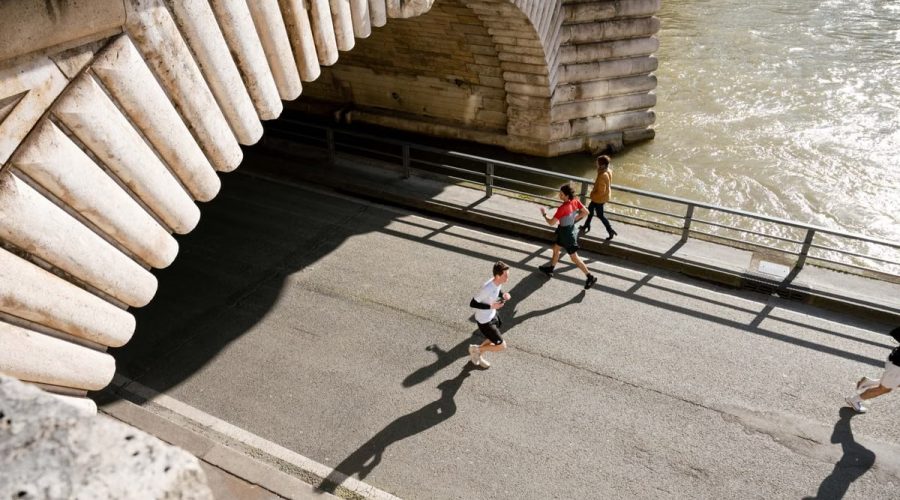 View of joggers running under the Pont de Bir-Hakeim in Paris, France during the day.